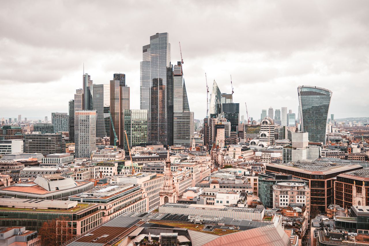 A stunning aerial view of London's modern skyscrapers under overcast skies, showcasing its architectural marvels.